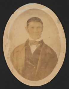 A man in early nineteenth-century dress-high-collared white shirt, cravat, vest, and wide-lapeled coat, in an oval picture.