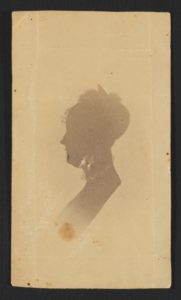 Silhouette of a woman, head and bust. The woman wears a high, lace-trimmed collar and a small bonnet.
